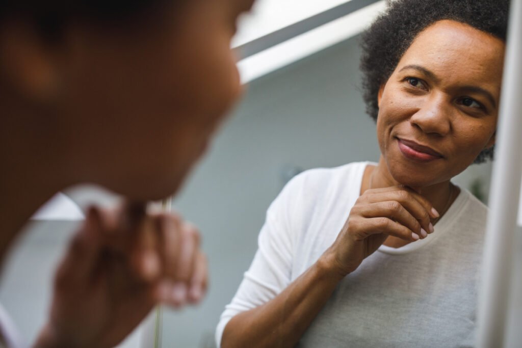 Woman in her 40s looking in the mirror