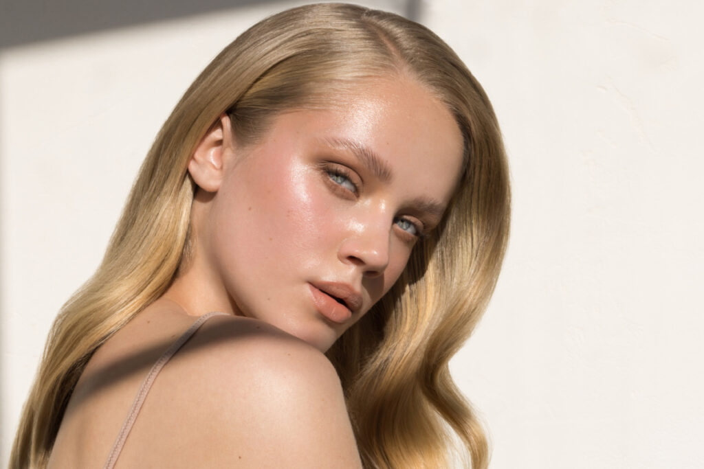 Young woman with blonde hair, blue eyes, and glowing, healthy skin