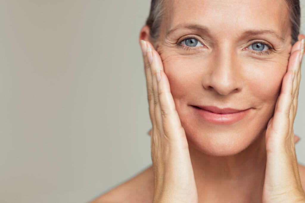 Mature woman smiling and touching face