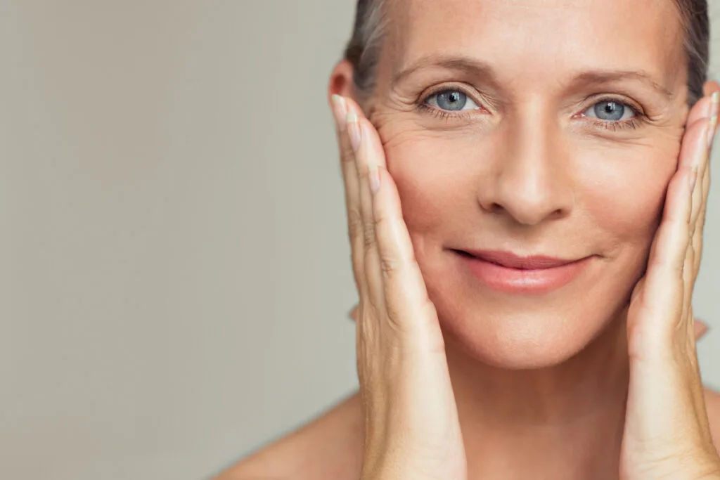 Mature woman smiling and touching face