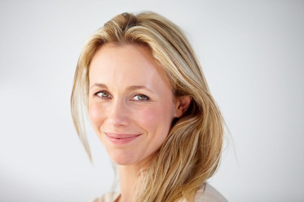 Close up of a blonde woman with hooded almond shaped eyes