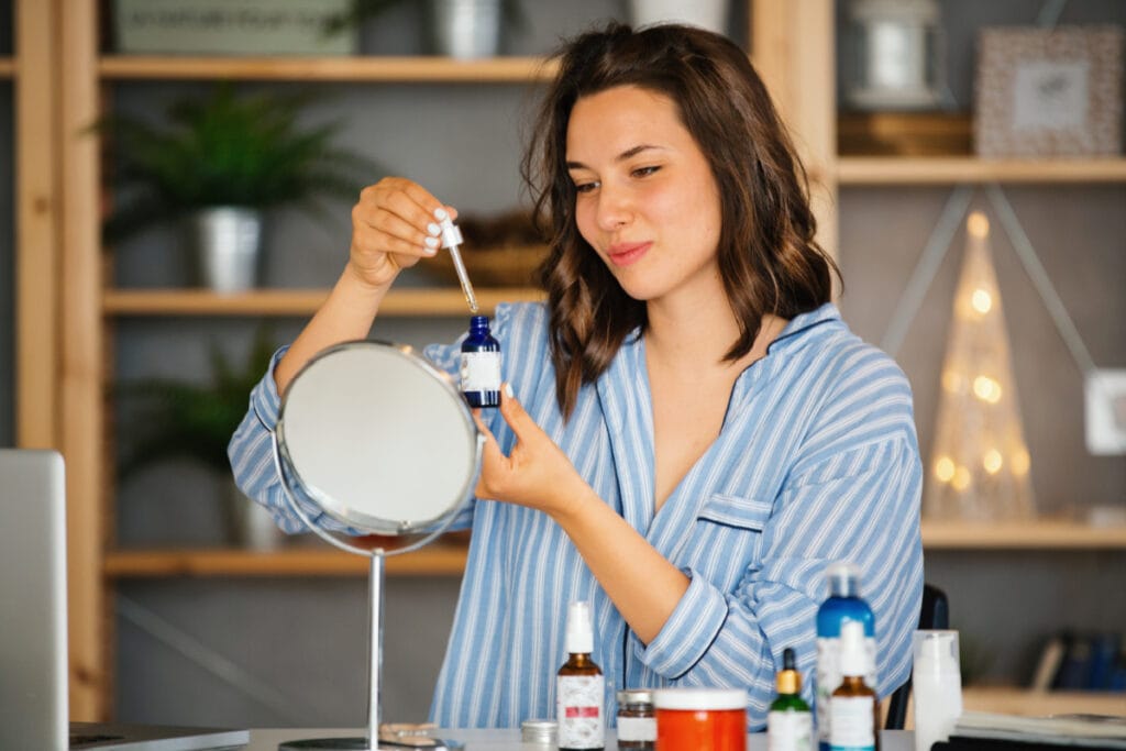Woman applying vitamin c skincare serum